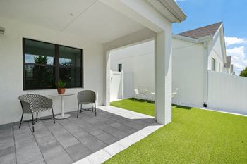 A patio with two chairs and a table on a patio